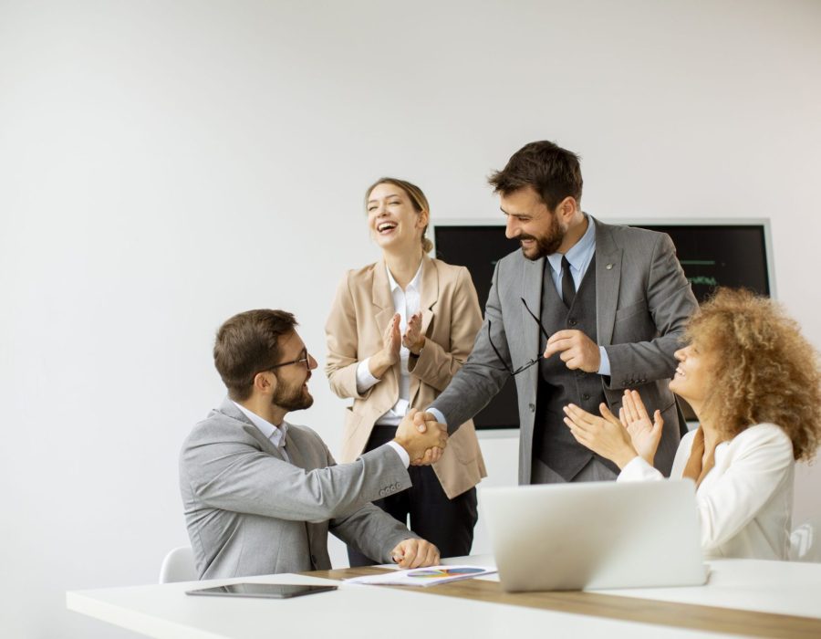Young business people sitting at meeting table in conference room discussing work and planning strategy